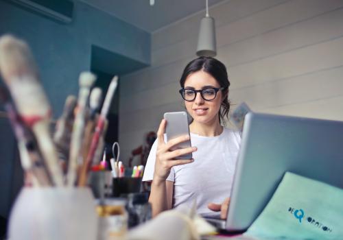 woman-in-white-t-shirt-holding-smartphone-in-front-of-laptop-914931-Foto de Andrea Piacquadio no Pexels