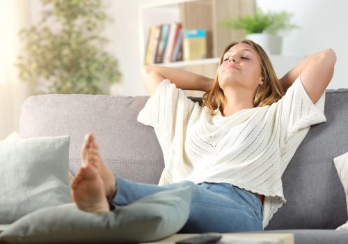 Carefree woman relaxing sitting on a sofa at home