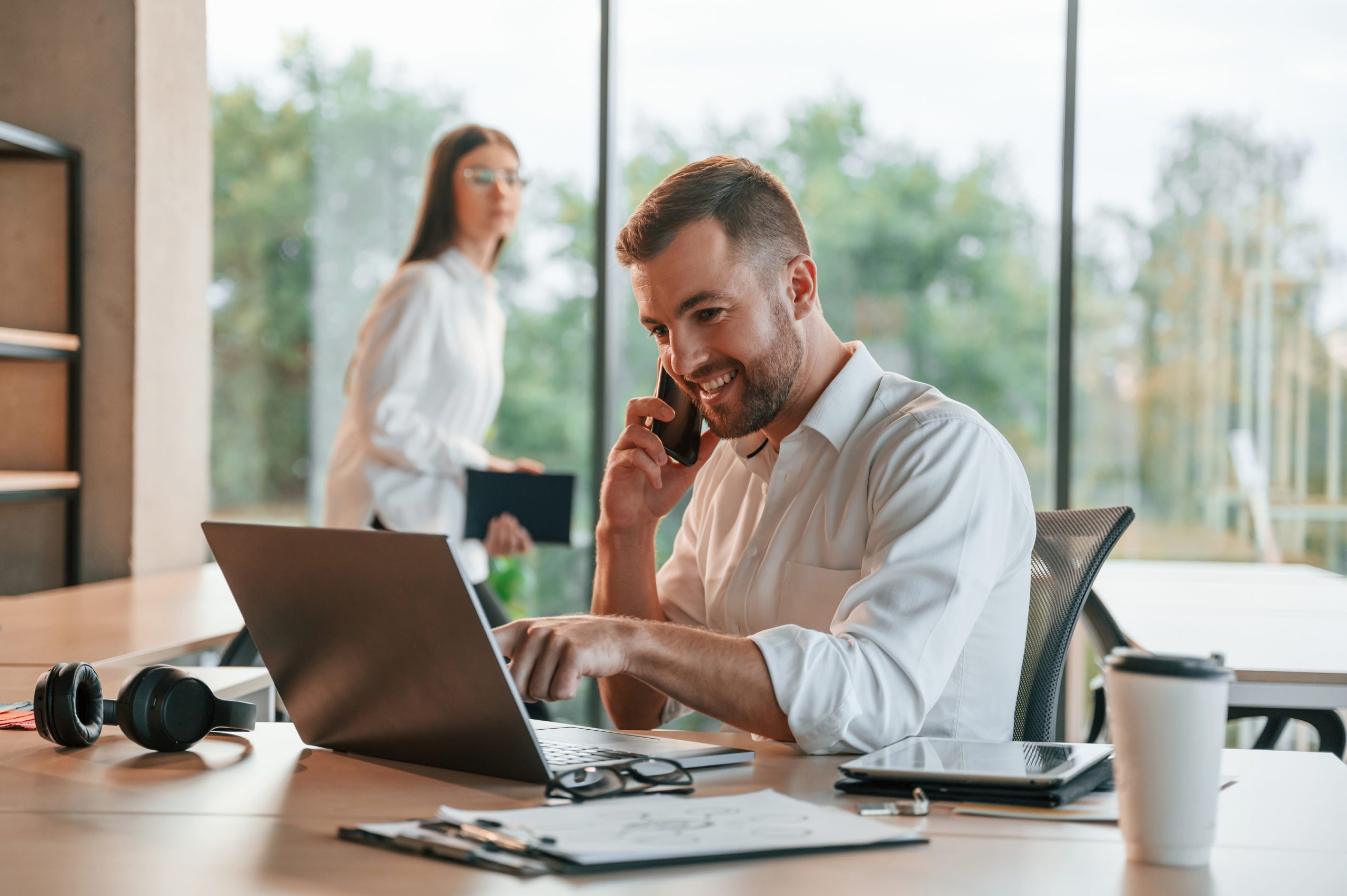 Successful deal. Using laptop. Man and woman are working in the modern office together
